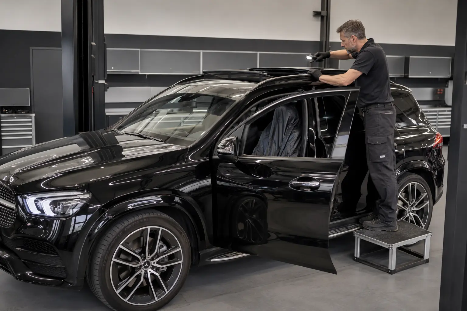 Technician inspecting a Mercedes-Benz panoramic sunroof